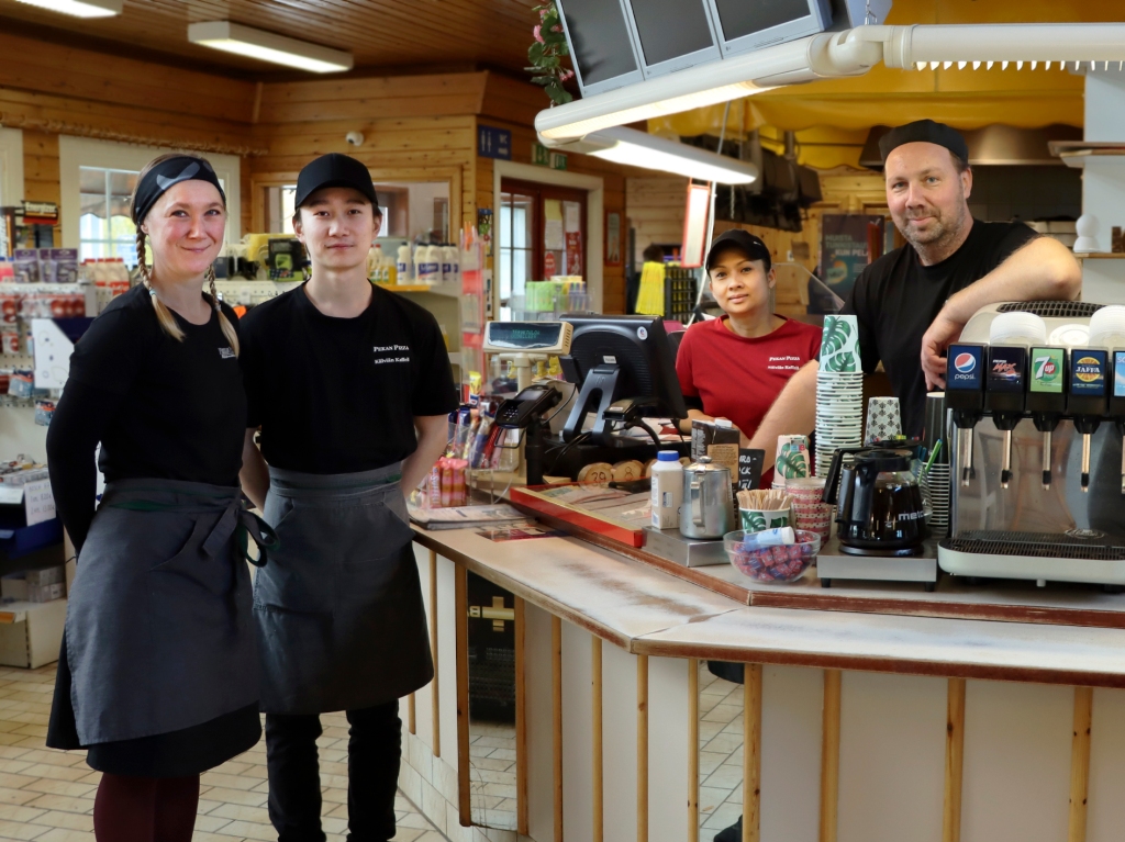 Sanna, Jimmy, Kitchadaporn sekä Pekka seisovat ravintolan sisällä tiskin ääressä.